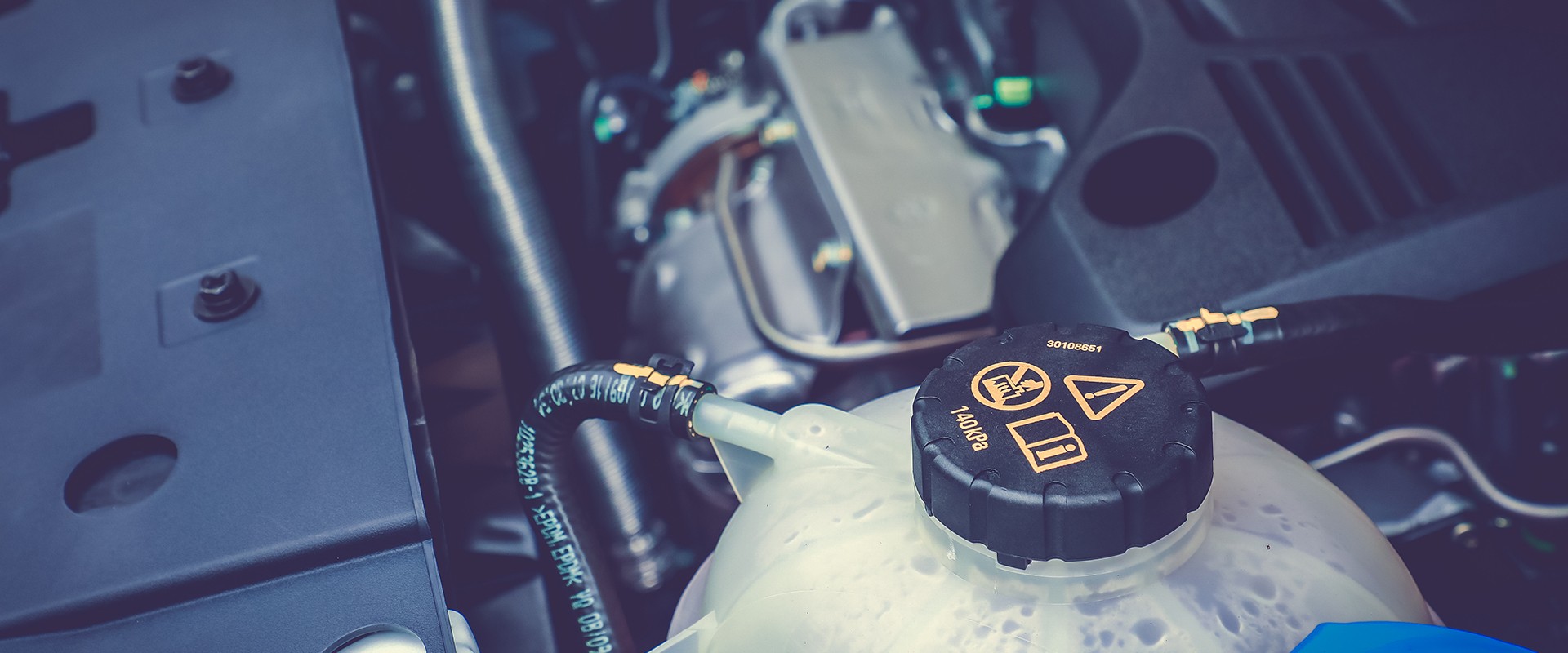 Tank of cooling liquid in engine interior